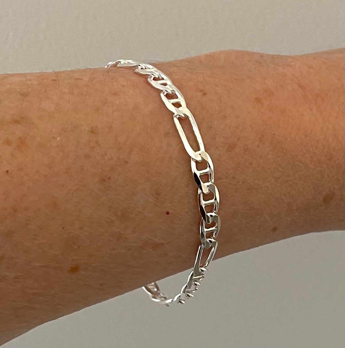 sterling silver figaro bracelet on wrist